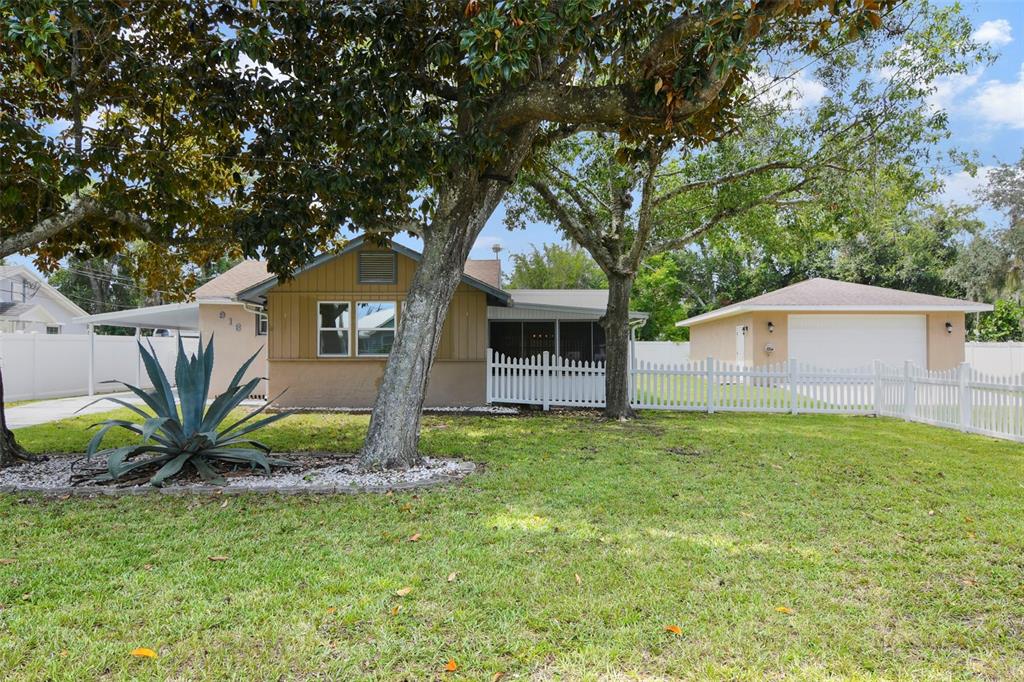 916 Fernald Street Edgewater, FL 32132 - Photo 24 of 27 a front view of a house with a garden and trees