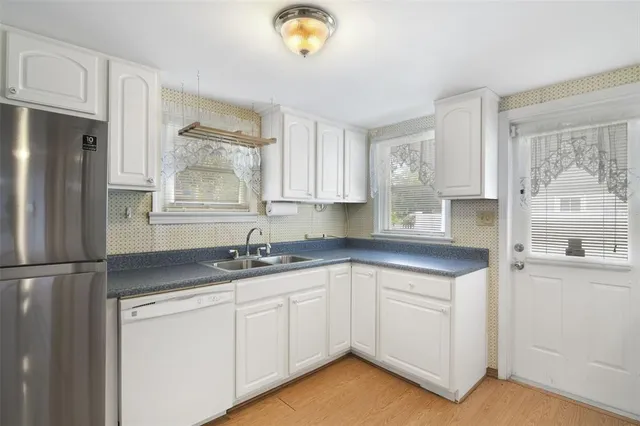 a kitchen with granite countertop a sink stainless steel appliances and cabinets