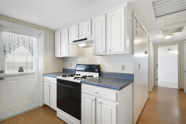 a kitchen with white cabinets and a stove