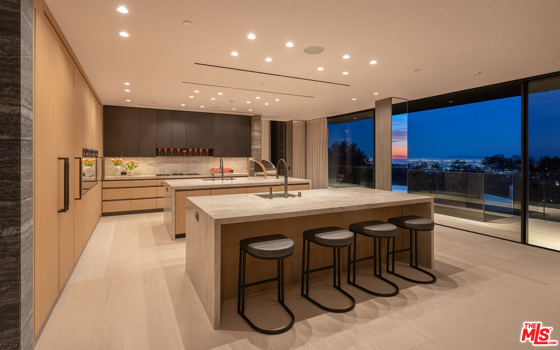 684 Firth Avenue Los Angeles, CA 90049 - Photo 18 of 27 a kitchen with stainless steel appliances granite countertop a table chairs sink and cabinets
