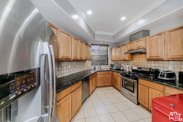 a kitchen with stainless steel appliances granite countertop a stove sink and cabinets