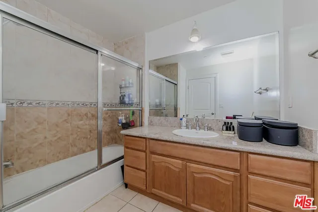 a bathroom with a granite countertop sink a mirror and a shower