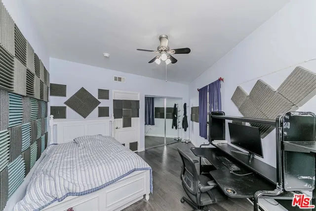 a bedroom with a bed gym equipment and a large window