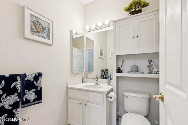 a bathroom with a toilet sink and mirror