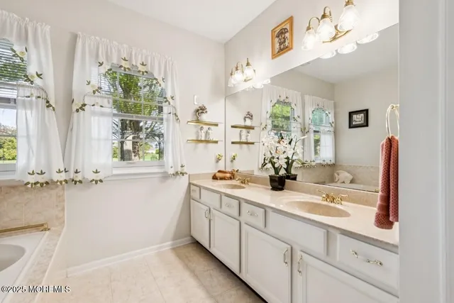 a bathroom with a sink a large mirror and a window