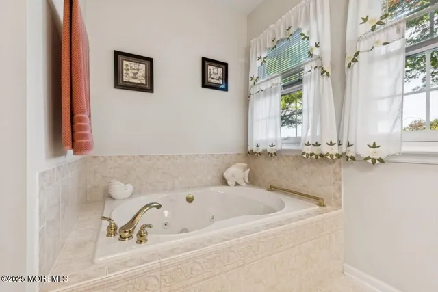 a bathroom with bathtub and a window