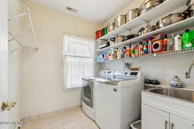 a utility room with stainless steel appliances a sink a stove and a window
