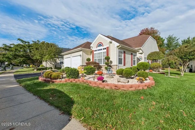 a front view of a house with a yard and trees