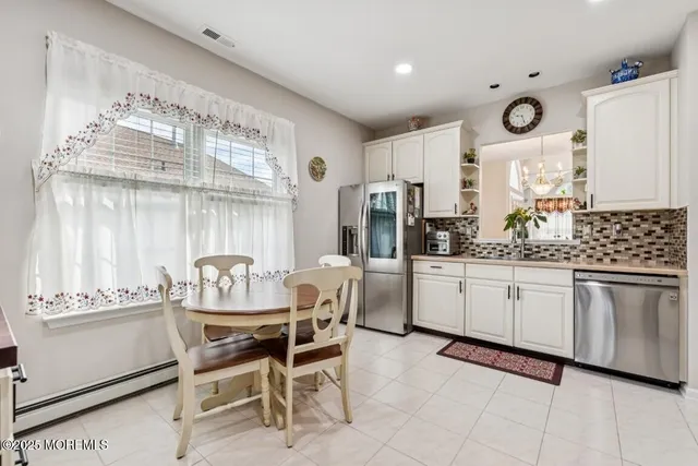 a kitchen with cabinets and chairs