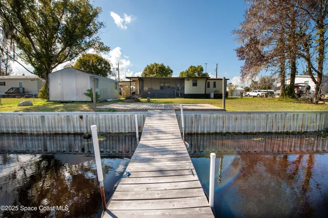 a living room with furniture a flat screen tv and a large window