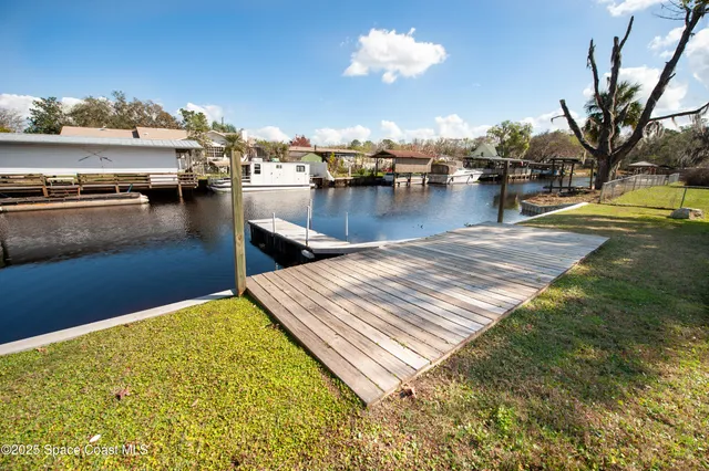 a living room with furniture a flat screen tv and kitchen view