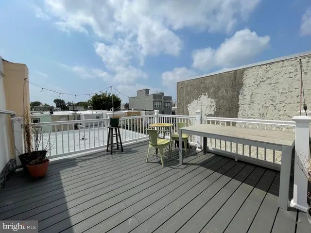 a view of a roof deck with chair and wooden floor