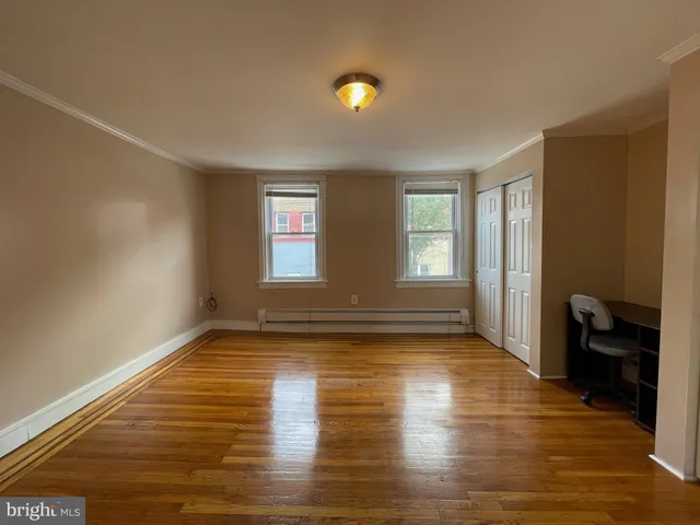 a view of empty room with kitchen and window