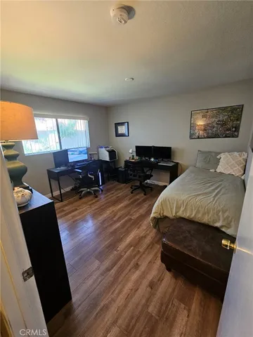 a spacious bedroom with a bed and wooden floor