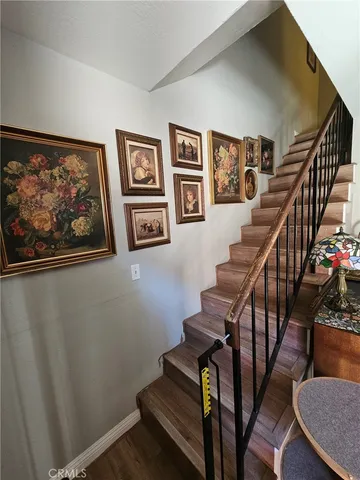 a view of staircase with furniture and lots of frames on wall