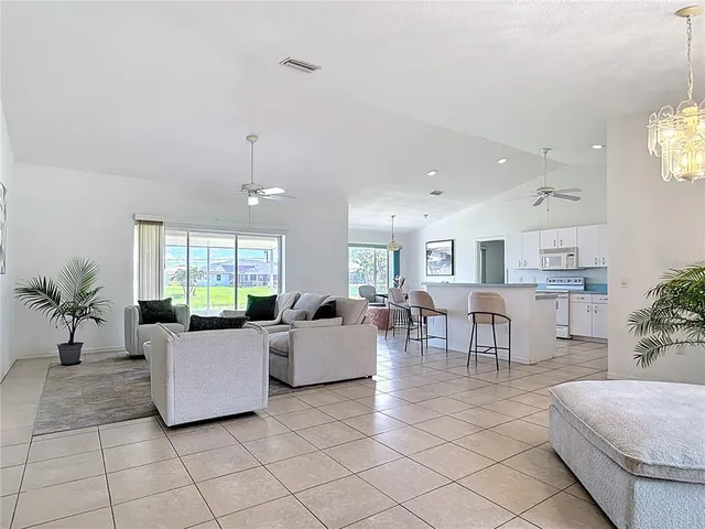 a bed sitting in a bedroom next to a window and a chandelier