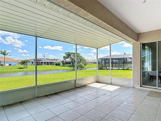 a house that is sitting in the grass with large trees and plants