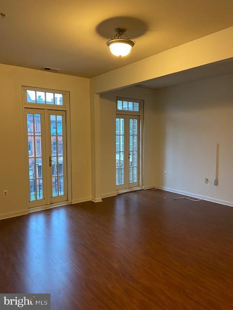 2511 Eutaw Place, Unit 402 Baltimore, MD 21217 - Photo 12 of 18 a view of an empty room with wooden floor and a window