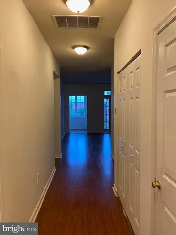 a empty room with wooden floor and a bathroom