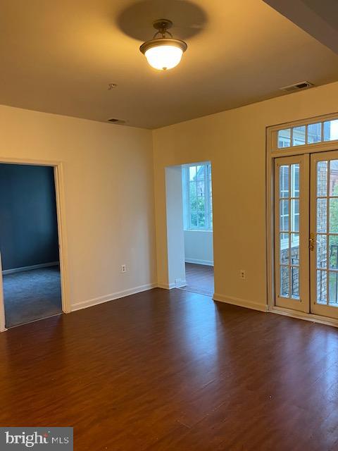 2511 Eutaw Place, Unit 402 Baltimore, MD 21217 - Photo 9 of 18 a view of an empty room with wooden floor and a window