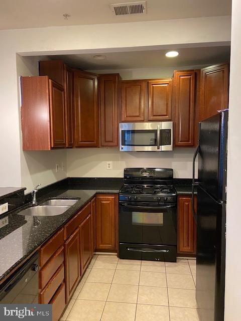2511 Eutaw Place, Unit 402 Baltimore, MD 21217 - Photo 10 of 18 a kitchen with granite countertop a stove a microwave a sink and cabinets