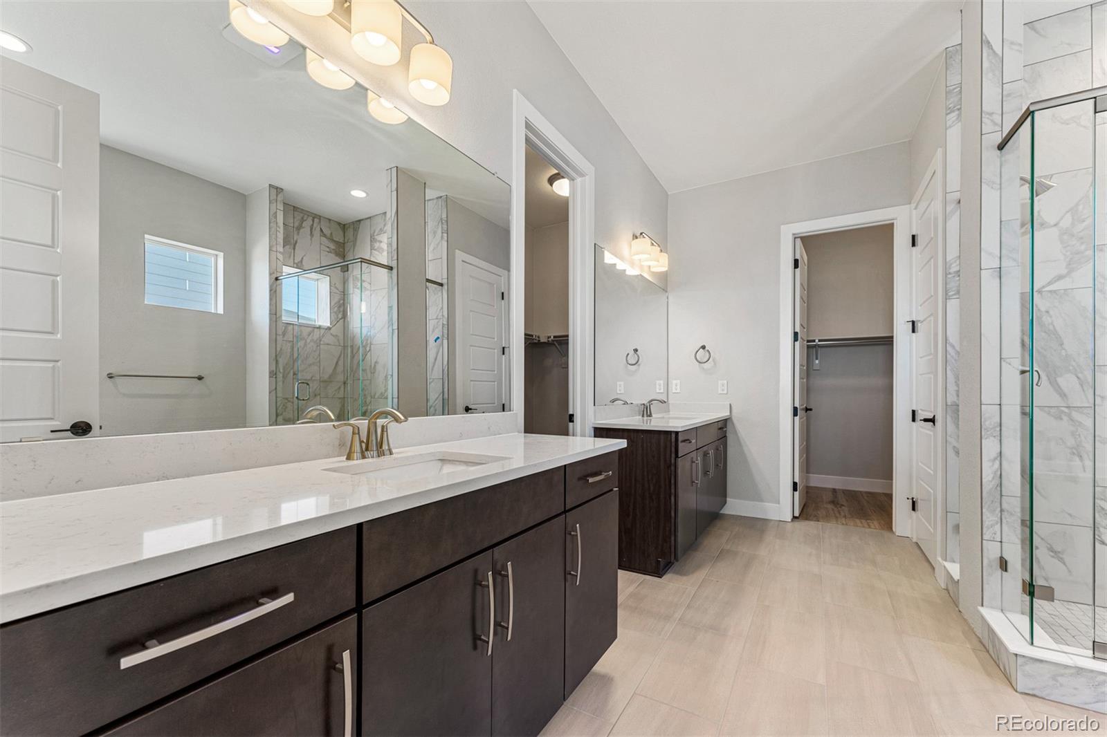 75 Clara Place Castle Pines, CO 80108 - Photo 19 of 39 a spacious bathroom with a double vanity sink mirror double and shower
