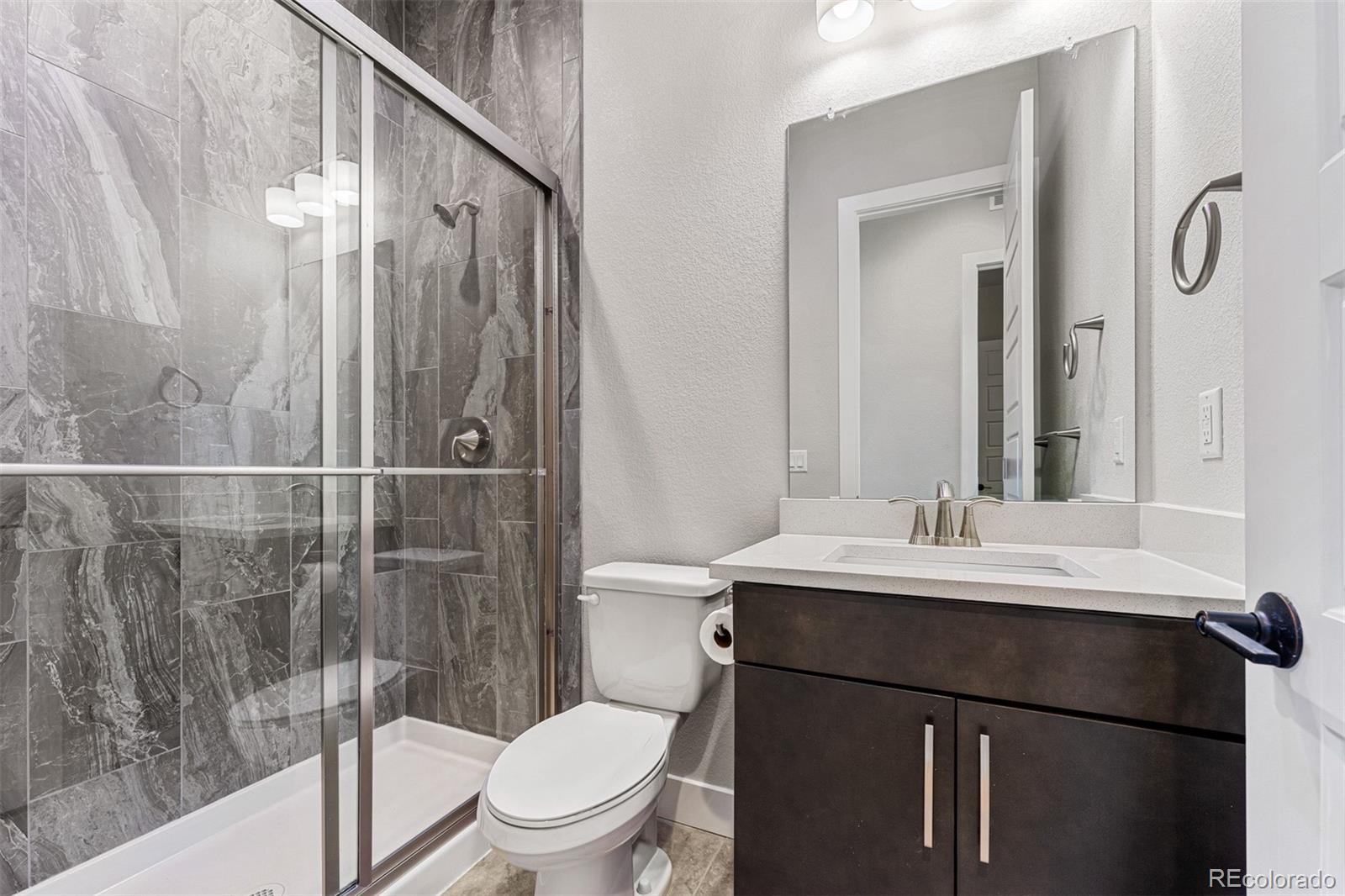75 Clara Place Castle Pines, CO 80108 - Photo 25 of 39 a bathroom with a sink toilet and shower