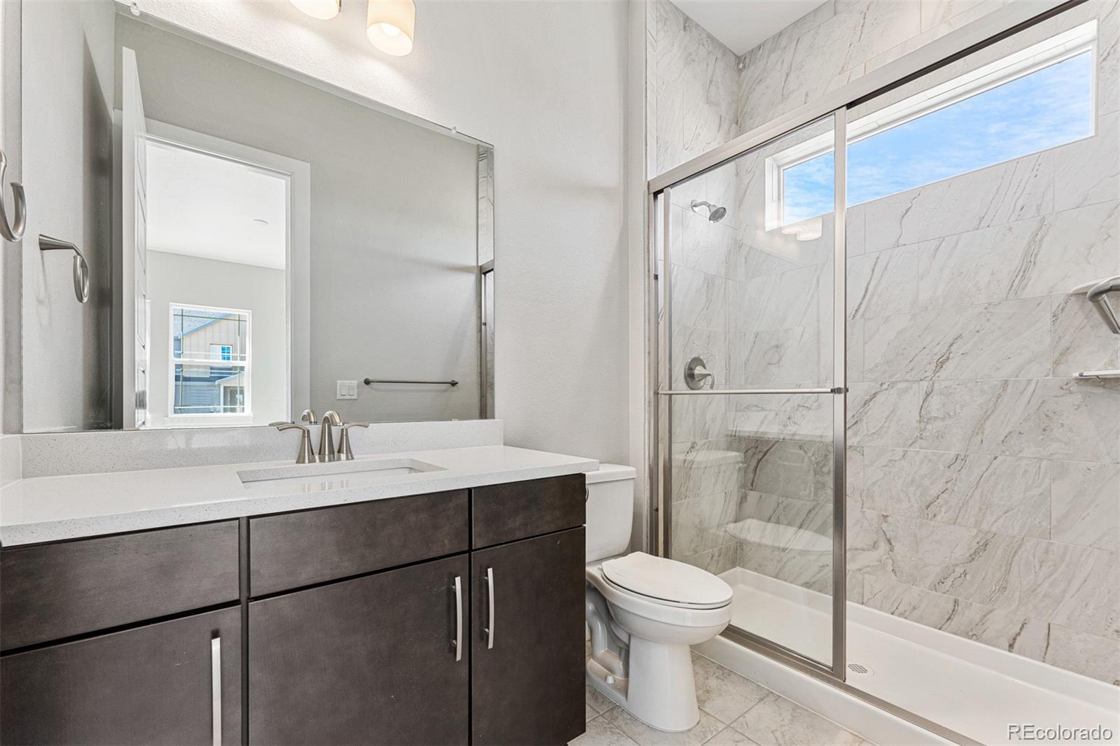 75 Clara Place Castle Pines, CO 80108 - Photo 29 of 39 a bathroom with a sink toilet and shower