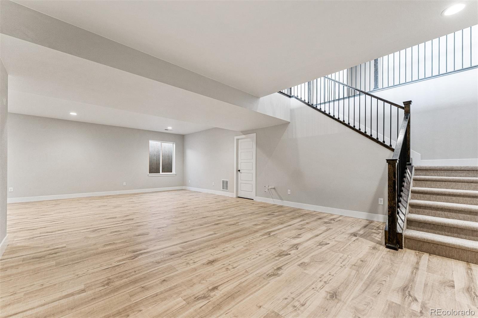 75 Clara Place Castle Pines, CO 80108 - Photo 30 of 39 a view of an empty room with wooden floor and stairs