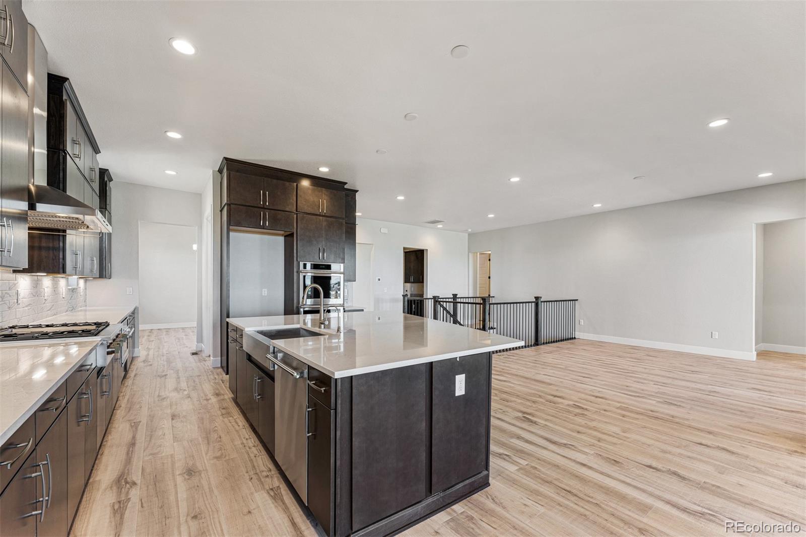 75 Clara Place Castle Pines, CO 80108 - Photo 5 of 39 a large kitchen with stainless steel appliances a large counter top and a stove