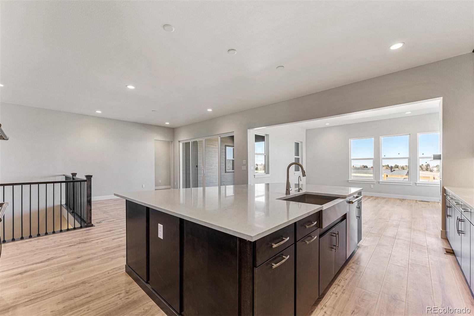 75 Clara Place Castle Pines, CO 80108 - Photo 6 of 39 a open kitchen with kitchen island a sink and wooden floor