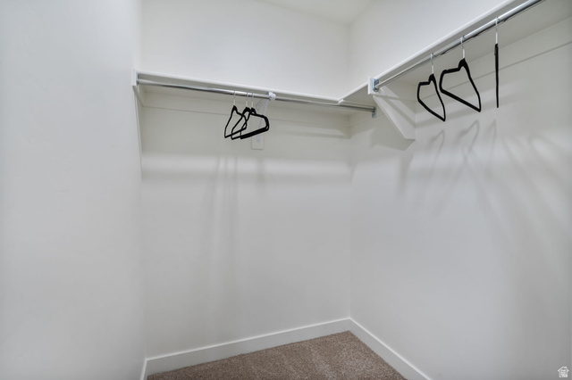 449 West 980th South Ogden, UT 84404 - Photo 15 of 23 Walk-in closet with carpet flooring, white walls, and built-in shelving with metal hanging rods