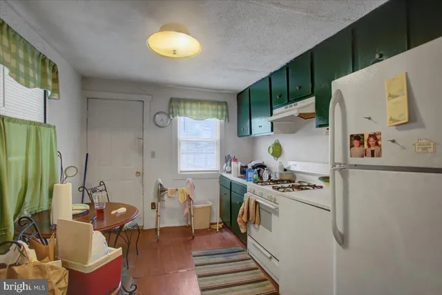 a kitchen with stainless steel appliances granite countertop a stove a refrigerator and a dining table view