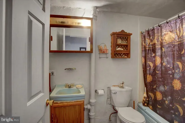 a bathroom with a toilet a sink and shower