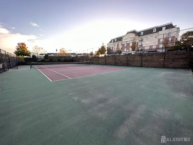 a view of a garden with flowers and brick wall