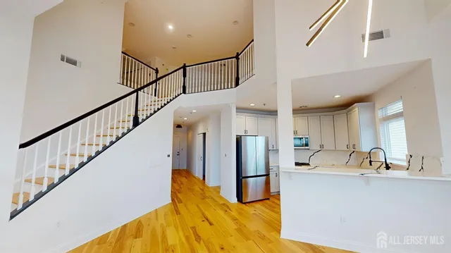 a view of a kitchen with stainless steel appliances a refrigerator a sink and a stove