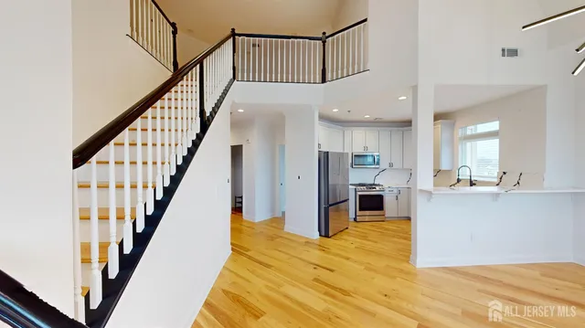 a view of a living room with wooden floor and staircase