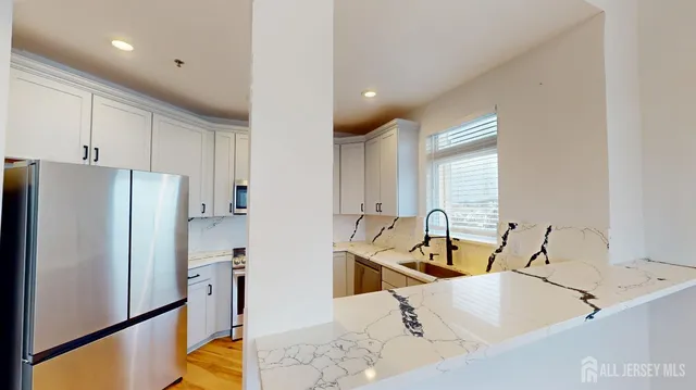 a kitchen with stainless steel appliances sink refrigerator and window