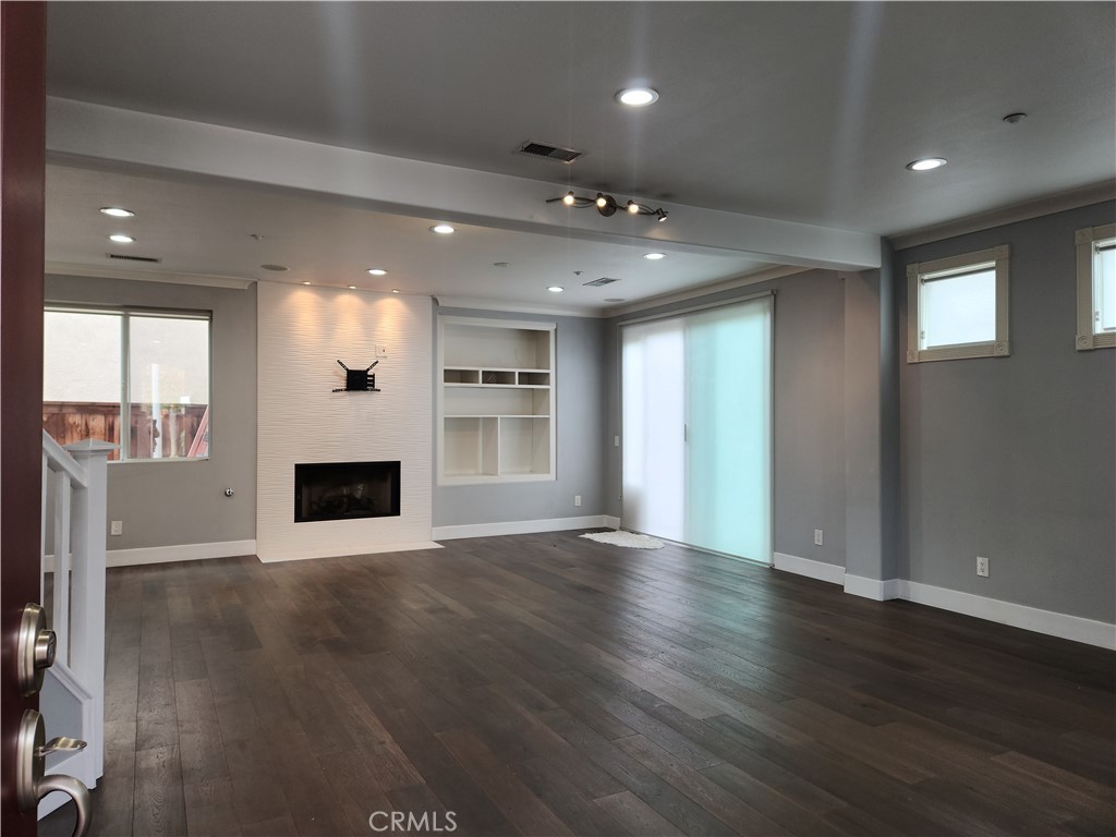 4540 Springleaf Lane Riverside, CA 92505 - Photo 4 of 32 an empty room with wooden floor and entrance to ceiling window