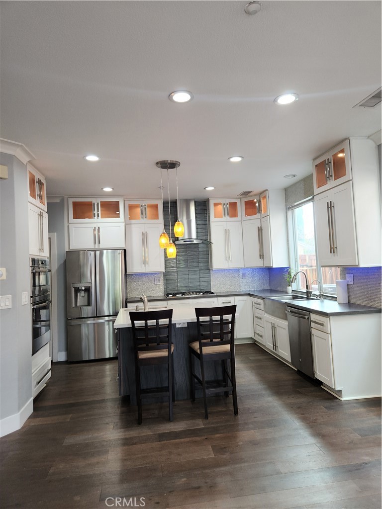 4540 Springleaf Lane Riverside, CA 92505 - Photo 6 of 32 a kitchen with stainless steel appliances kitchen island granite countertop a table chairs stove and refrigerator