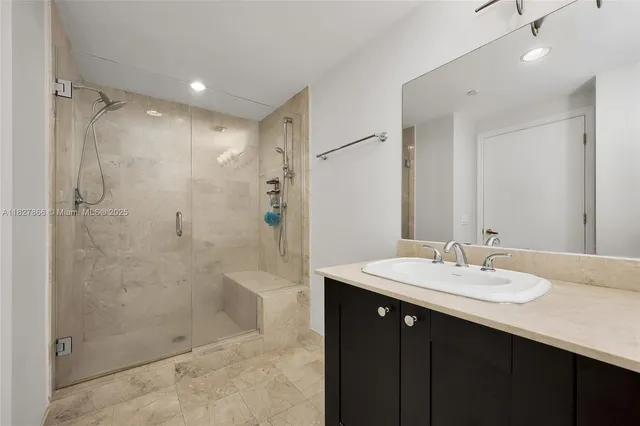 a bathroom with a sink shower and a mirror