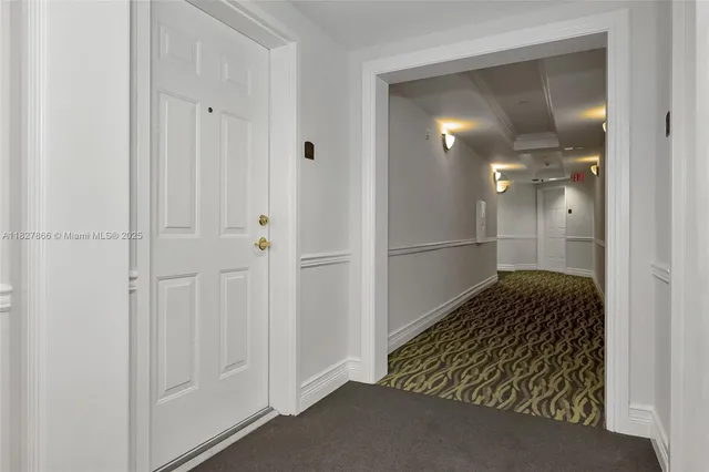 a view of a hallway with wooden cabinets