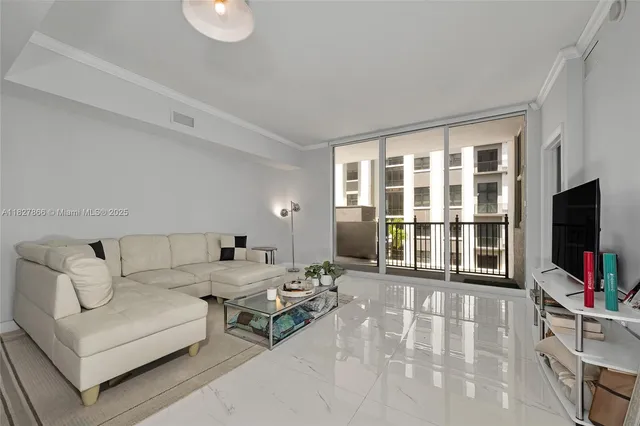 a living room with furniture a flat screen tv and a floor to ceiling window