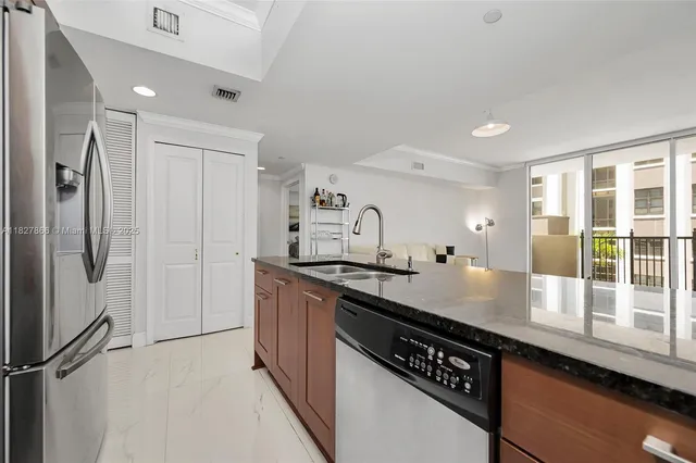 a kitchen with granite countertop a sink and stainless steel appliances