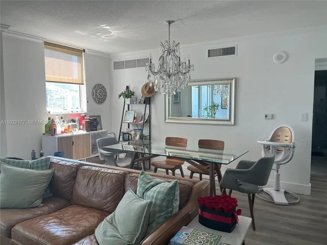 a living room with furniture a chandelier and a window