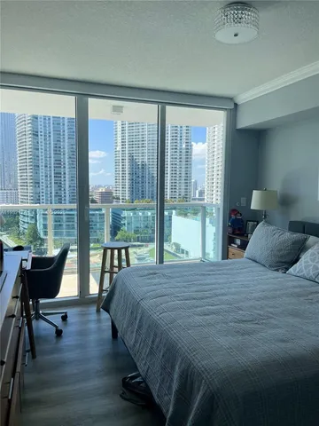 a bedroom with a bed and large windows