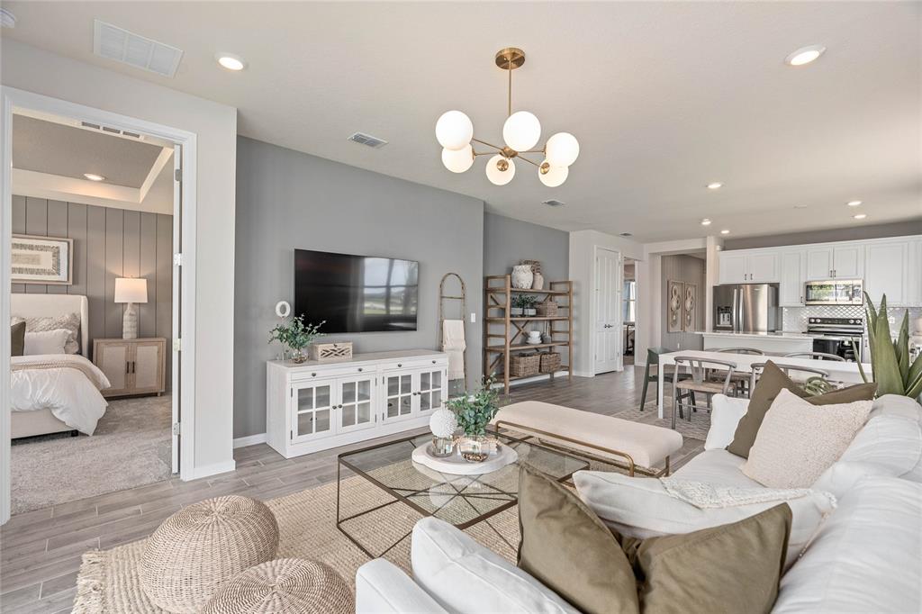 6300 Dew Drop Loop St. Cloud, FL 34771 - Photo 12 of 29 a living room with furniture a flat screen tv and kitchen view
