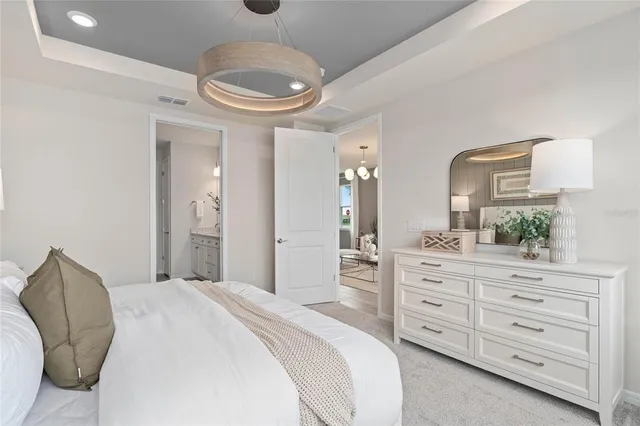 a spacious bedroom with a bed and a dresser