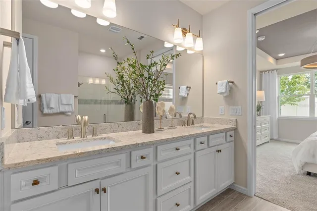 a bathroom with a granite countertop double vanity sink mirror and view
