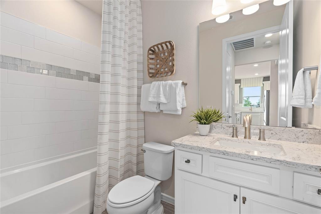 6300 Dew Drop Loop St. Cloud, FL 34771 - Photo 26 of 29 a bathroom with a granite countertop toilet a sink and a bathtub